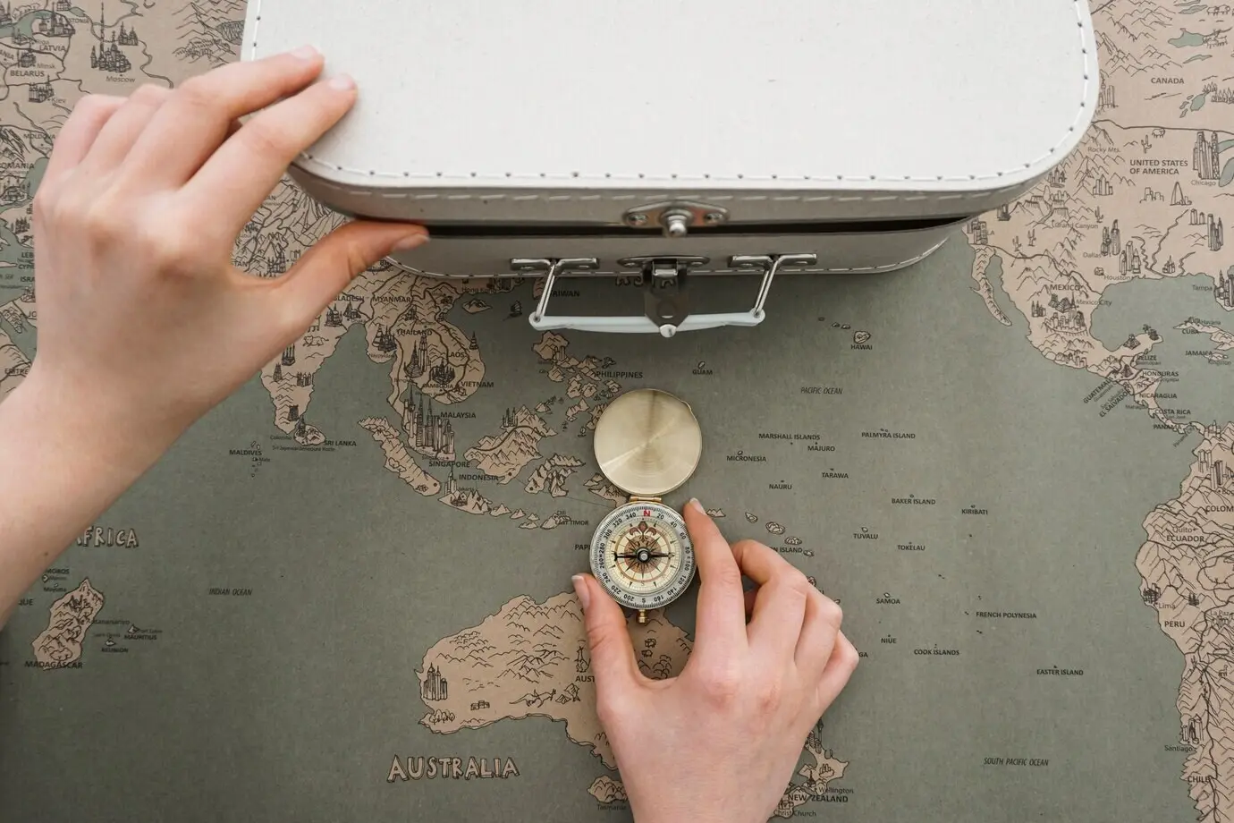 Ansicht von oben auf eine Abenteuer-Komposition mit Kompass und Koffer.